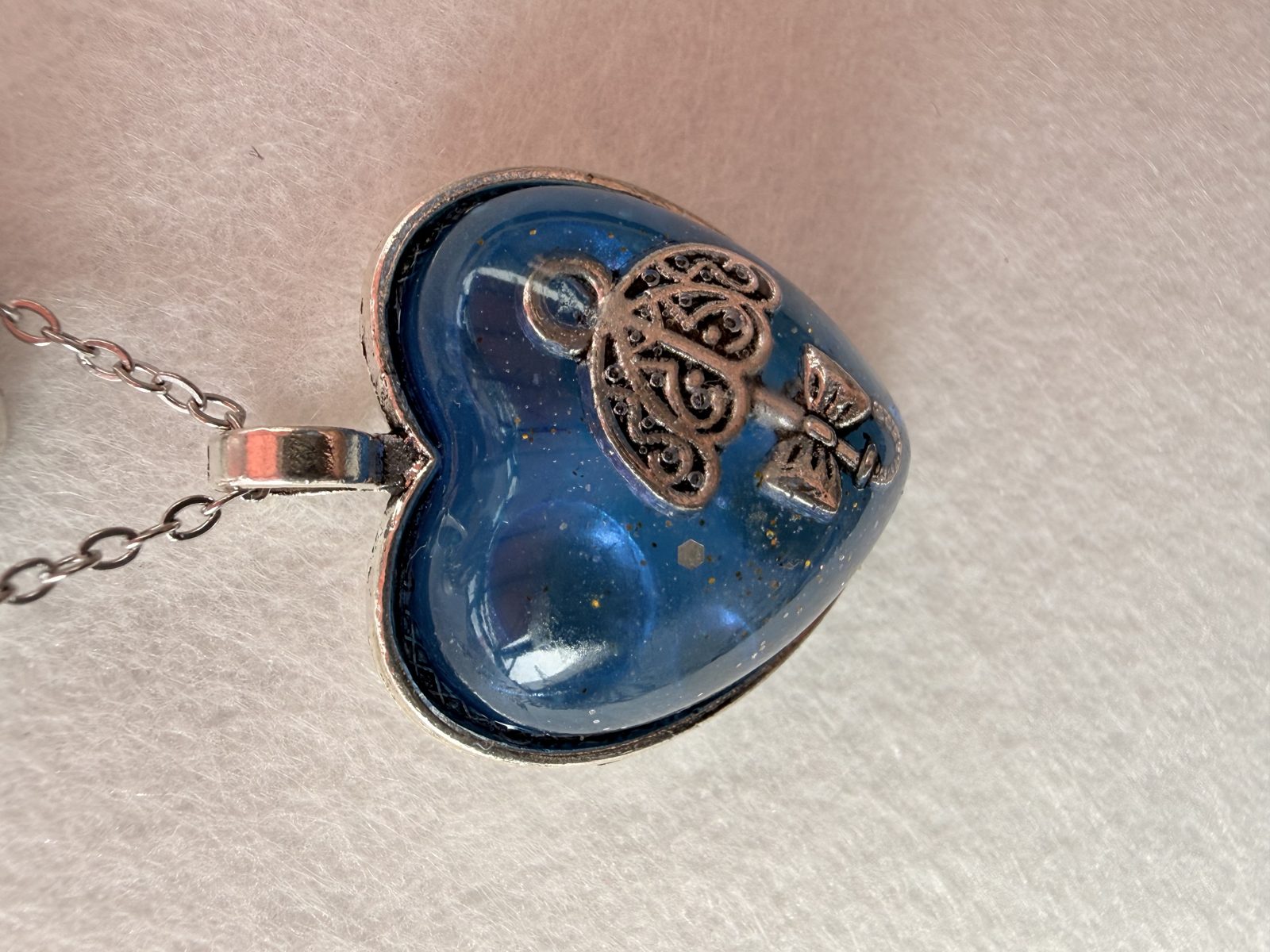 Heart-shaped blue resin pendant with a silver key on a silver chain